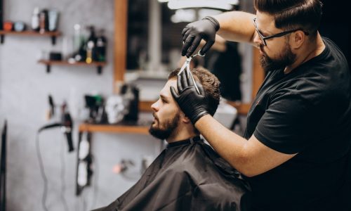Client doing hair cut at a barber shop salon